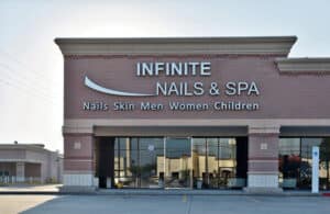 Exterior of Infinite Nails & Spa storefront with sleek, professional signage on a brick building