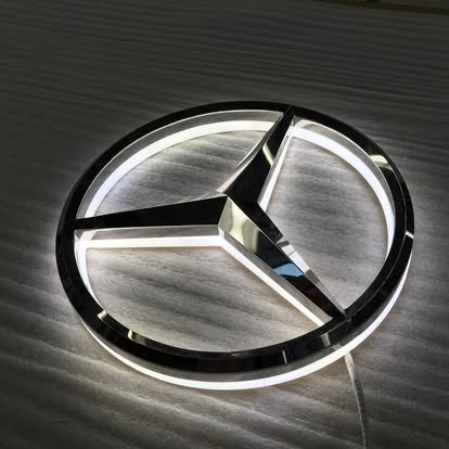 Illuminated corporate logos, like this Mercedes-Benz emblem, often utilize premium materials and finishes to create a sophisticated visual impact and reinforce brand identity.