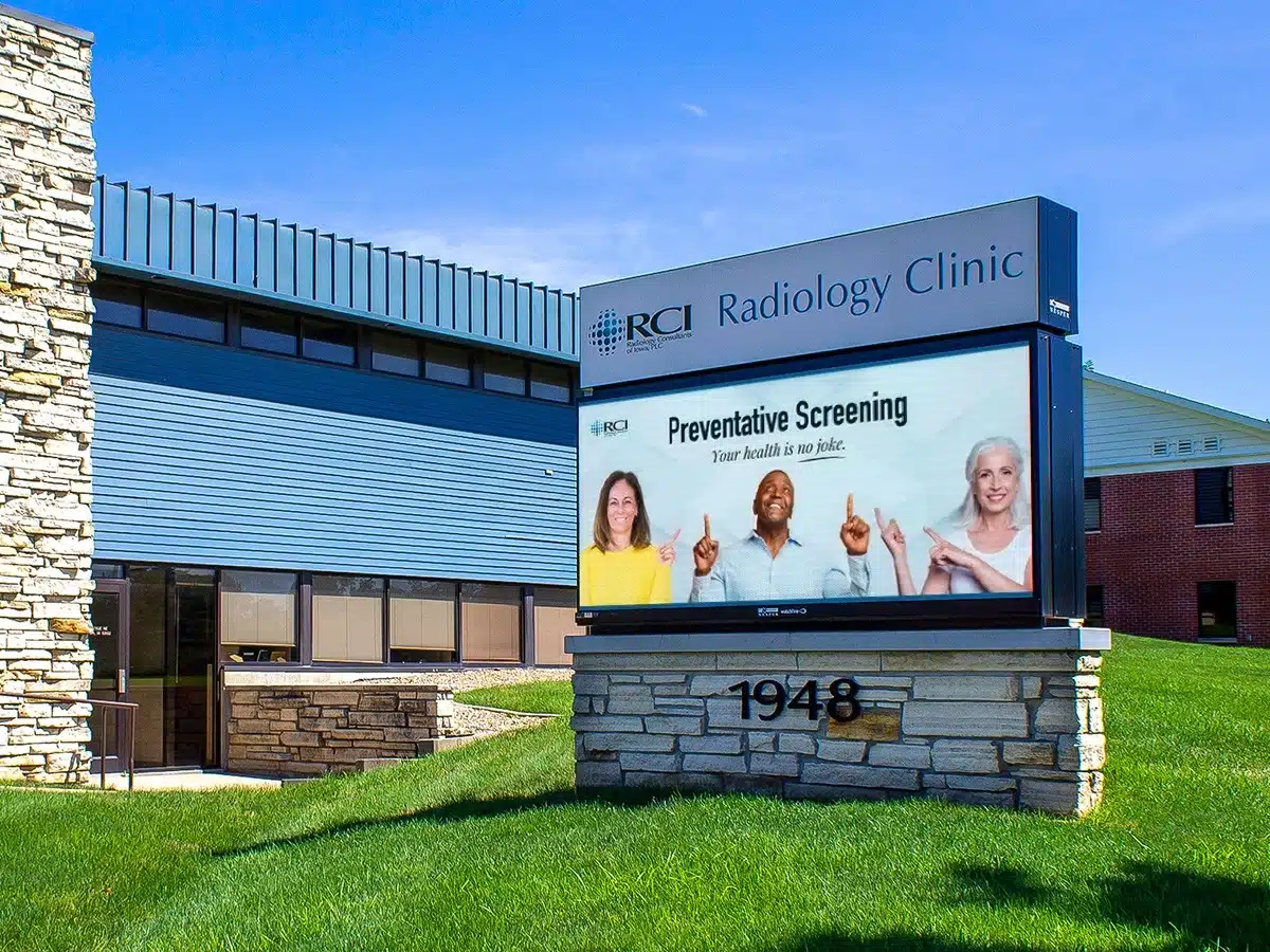 Professional monument sign for RCI Radiology Clinic with clear branding, the clinic's name, and information about preventative screening, set in front of the medical building.