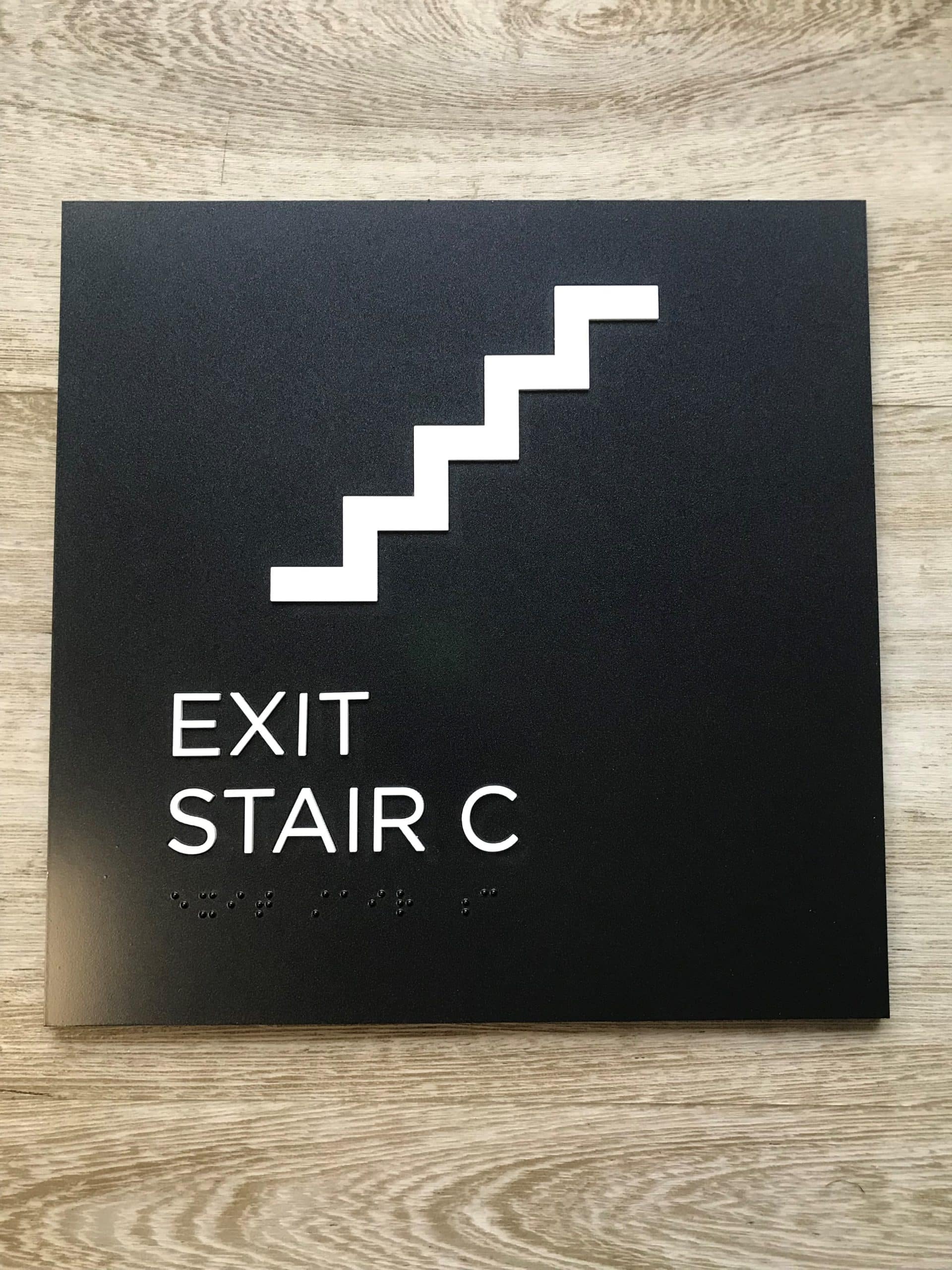 https://tuppsigns.com/revitalize-your-brand-signage-upgrades-for-established-businesses/ ADA-compliant black sign with high contrast white text indicating "EXIT STAIR C".