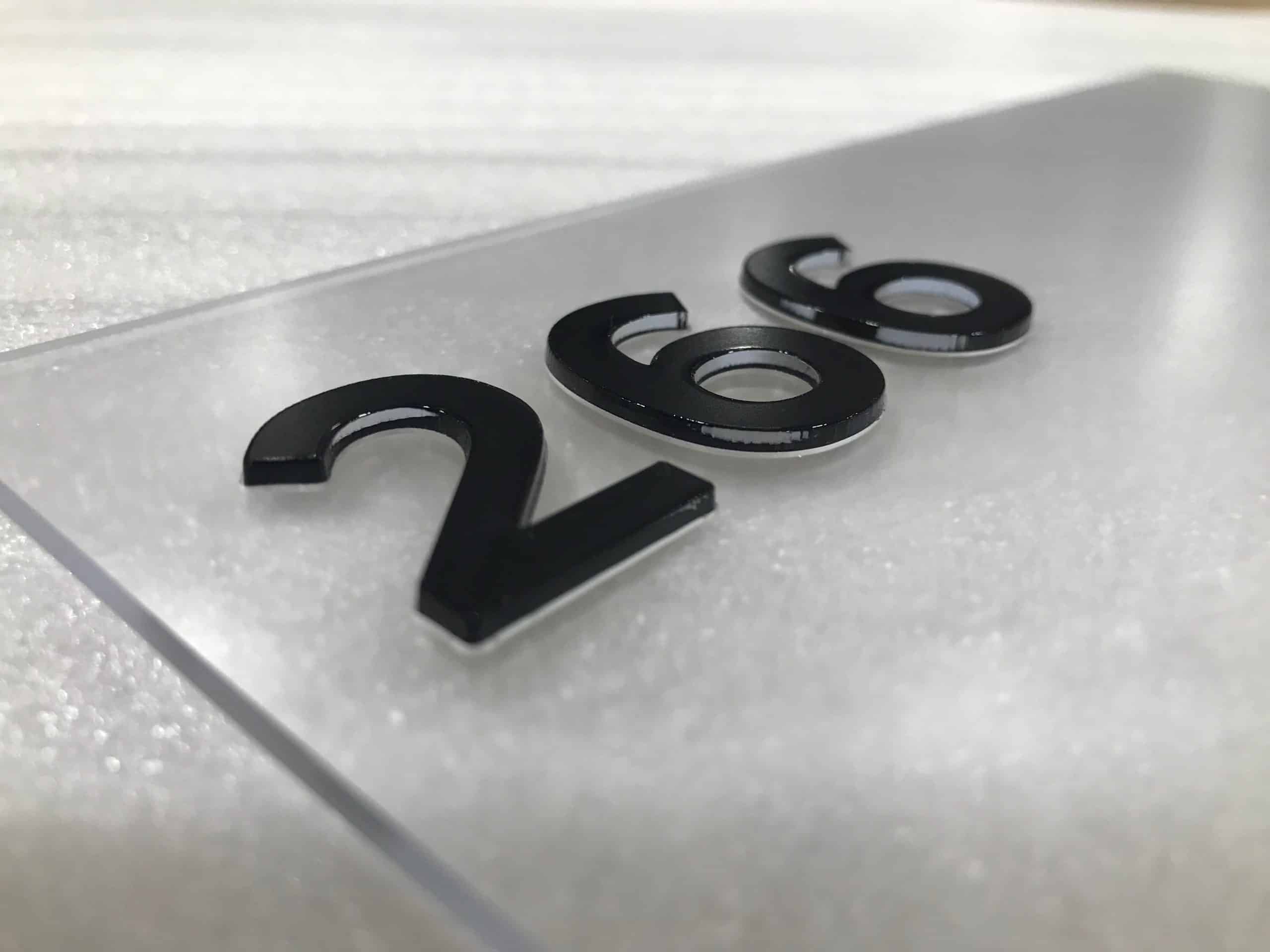 Close-up of a durable interior sign featuring the room number "266" with black inlaid lettering on a frosted acrylic or similar material, suggesting a high-quality and long-lasting design.